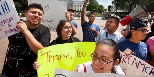 FILE - In this June 15, 2012 file photo, young demonstrators participate in a rally in support of President Barack Obama after the president announced that the U.S. government will stop deporting and begin granting work permits to younger illegal immigrants who came to the U.S. as children and have since led law-abiding lives. Young Hispanic and Asian-Americans who are immigrants themselves or have a parent who is are more likely to be liberal in their views on politics and immigration than those with families who have been in United States longer, a new GenForward poll shows. (AP Photo/Jacquelyn Martin, File)