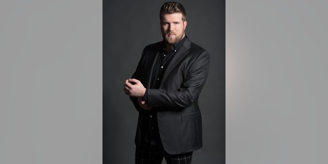 Plus-size male model Zach Miko poses.