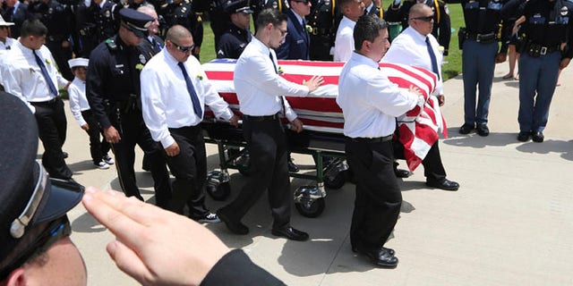 Pallbearers accompany the flag-draped coffin of slain Dallas police Officer Patrick Zamarripa in Dallas, July 16, 2016. Zamarripa was one of five officers killed by a lone gunman.