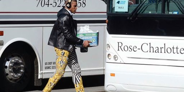 Carolina Panthers quarterback Cam Newton sports zebra-stripe pants as he moves to board a bus on his way to the airport to head to San Francisco for Super Bowl 50 against the Denver Broncos.