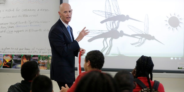 Florida Gov. Rick Scott talks with students who are studying the Zika virus, while visiting a classroom on the first day of school at the Jose de Diego Middle School, Monday, Aug. 22, 2016, in the Wynwood neighborhood of Miami. Mosquito-borne Zika cases have been found in an area of Wynwood, and in a section of Miami Beach. The CDC has issued an advisory for pregnant women to avoid travel to these two zones. (AP Photo/Lynne Sladky)