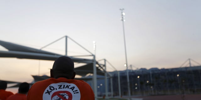 A worker from a public cleaning company wears a T-shirt that reads "Out Zika" is pictured before the inauguration ceremony of the common areas and the Live Site at the 2016 Rio Olympics park in Rio de Janeiro, Brazil, April 11, 2016.