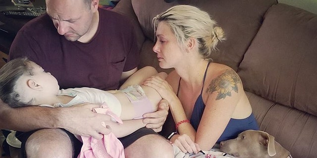 Ben and Casey Daggett hold their daughter Zoey in their arms just hours before she passed away.