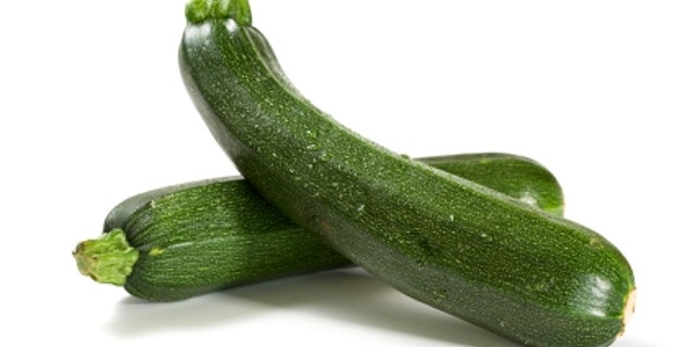 two zucchini with water drops isolated on white