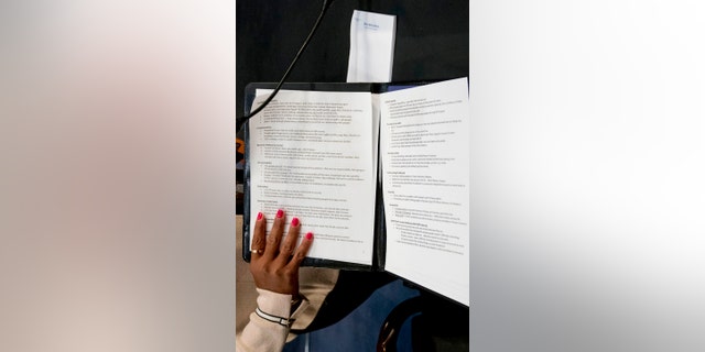 An aide to Facebook CEO Mark Zuckerberg closes a binder of notes left on the table as Zuckerberg takes a short break from testifying before a joint hearing of the Commerce and Judiciary Committees on Capitol Hill in Washington, Tuesday, April 10, 2018, about the use of Facebook data to target American voters in the 2016 election. (AP Photo/Andrew Harnik)