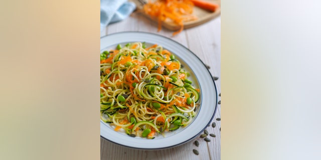 Home made frshness vegetarian noodles salad,made by courgette,carrot,and edamame beans and quiona,pumpkin seeds.