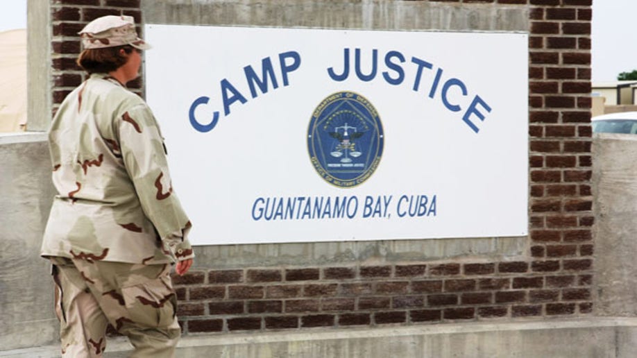  A U.S. Navy unit   is seen walking past   a monument astatine  Camp Justice, tract  of the subject   committee  courthouse wherever  Canadian national  Omar Khadr is acceptable   to beryllium  tried for warfare  crimes astatine  Guantanamo Bay, Cuba.