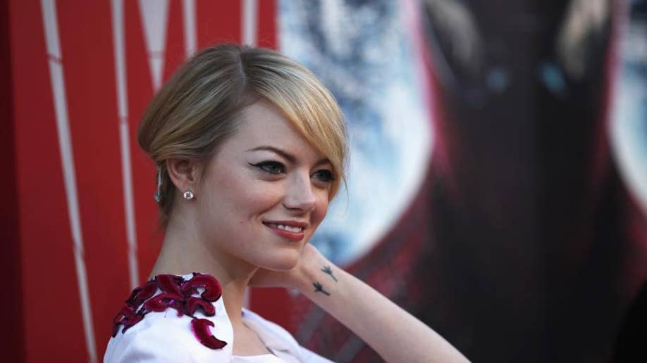 Emma Stone smiles on a red carpet