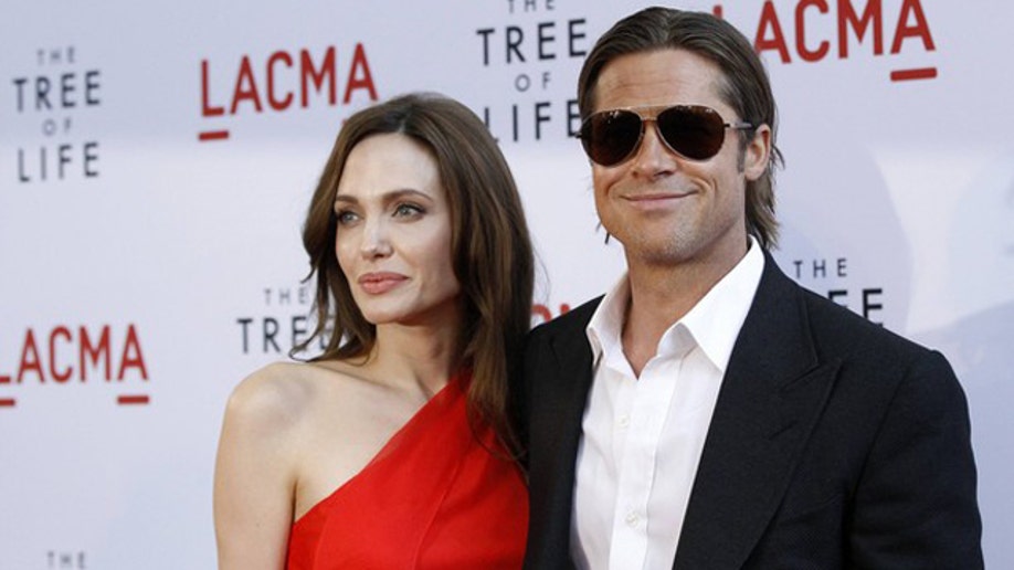 Cast member Brad Pitt and actress Angelina Jolie pose at the premiere of "The Tree of Life" at LACMA in Los Angeles May 24, 2011. The movie opens limitedly in the U.S. on May 27. REUTERS/Mario Anzuoni (UNITED STATES - Tags: ENTERTAINMENT)