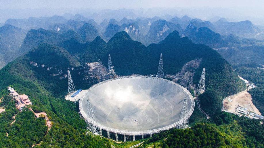 In this Saturday, Sept. 24, 2016 photo released by Xinhua News Agency, an aerial view shows the Five-hundred-meter Aperture Spherical Telescope (FAST) in the remote Pingtang county in southwest China's Guizhou province. China has begun operating the world's largest radio telescope to help search for extraterrestrial life. (Liu Xu/Xinhua via AP)