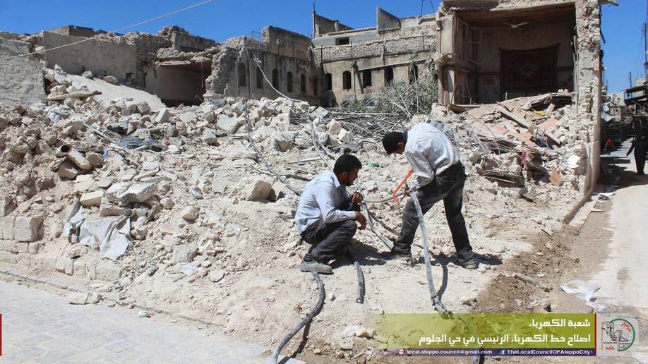 In this photo taken Aug. 20, 2016 and provided by the local council of Aleppo city, Syrians workers fix electricity cables after airstrikes, in Aleppo, Syria. The opposition-held districts of the Syrian city have been surrounded and under siege for months. Russian and Syrian warplanes are bombing the streets into rubble and government forces are chipping away at the pocket of opposition control. (Local Council of Aleppo City via AP)