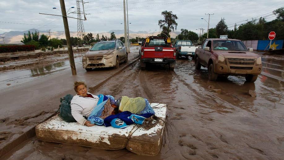 Communities in northern Chile dig out of mud after major floods kill 9
