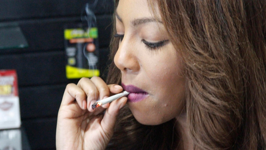 Feb. 20, 2015: Alaska Cannabis Club CEO Charlo Greene smokes a joint at the medical marijuana dispensary in Anchorage. (AP Photo/Mark Thiessen)