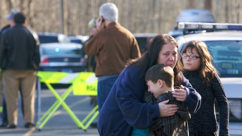 A young boy is comforted outside Sandy Hook Elementary School after a shooting in Newtown, Connecticut, December 14, 2012. A shooter opened fire at the elementary school in Newtown, Connecticut, on Friday, killing several people including children, the Hartford Courant newspaper reported. REUTERS/Michelle McLoughlin (UNITED STATES - Tags: CRIME LAW EDUCATION TPX IMAGES OF THE DAY)