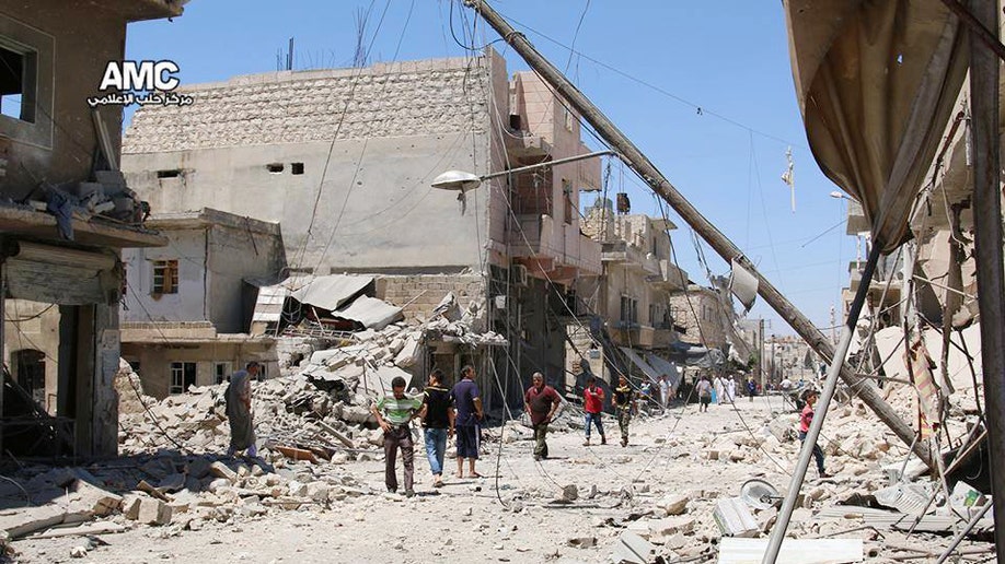 In this Wednesday, July. 27, 2016 photo, provided by the Syrian anti-government activist group Aleppo Media Center (AMC), shows Syrian citizens inspect damaged buildings after airstrikes hit Aleppo, Syria. Residents trapped in rebel-controlled Aleppo are struggling to survive the crippling encirclement of their once thriving city. Bread, medication and fuel are running short. For the tens of thousands who chose to remain, the battle for Aleppo is a pivot point in the Syrian war. (Aleppo Media Center via AP)