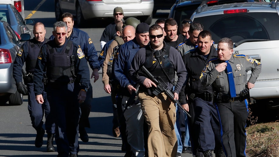 Police patrol the streets outside Sandy Hook Elementary School after a shooting in Newtown, Connecticut, December 14, 2012. At least 27 people, including children, were killed on Friday when at least one shooter opened fire at an elementary school in Newtown, Connecticut, CBS News reported, citing unnamed officials. REUTERS/Adrees Latif (UNITED STATES - Tags: CRIME LAW EDUCATION)