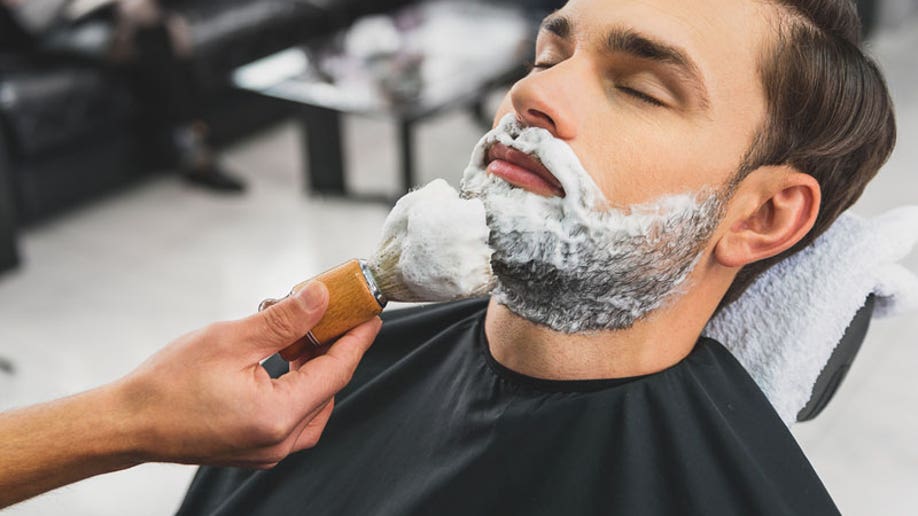 Man receiving a shave from a barber