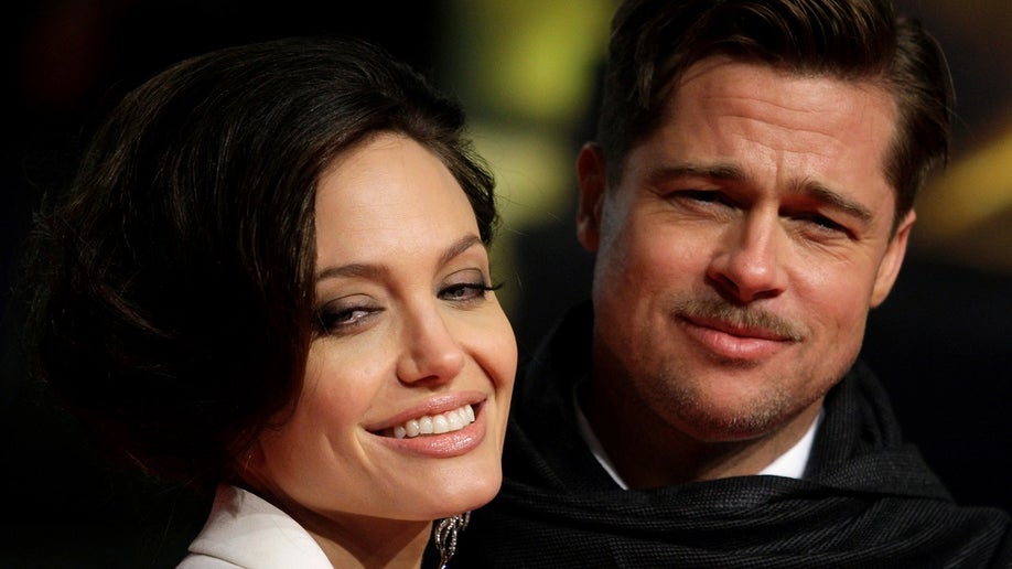 U.S. actors Brad Pitt and his partner Angelina Jolie pose for photographers on the red carpet at the German premiere of the movie "The Curious Case of Benjamin Button" in Berlin January 19, 2009. REUTERS/Hannibal Hanschke/File Photo TPX IMAGES OF THE DAY - RTSOLP8
