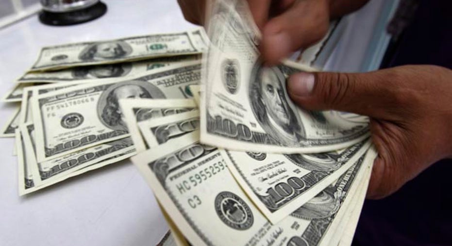 A worker counts U.S. dollar bills at a money changer in Manila August 10, 2011. The Philippines expects more money inflows after the Fed promised near zero rates up to 2013, potentially muddling monetary policy looking to bolster local demand, the central bank said on Wednesday. Policymakers would also continue a review of current rules to dampen volatilities in the foreign exchange market, Bangko Sentral ng Pilipinas (BSP) Governor Amando Tetangco said. REUTERS/Romeo Ranoco (PHILIPPINES - Tags: BUSINESS POLITICS)