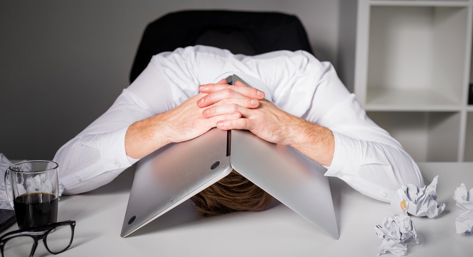 Man hiding under laptop