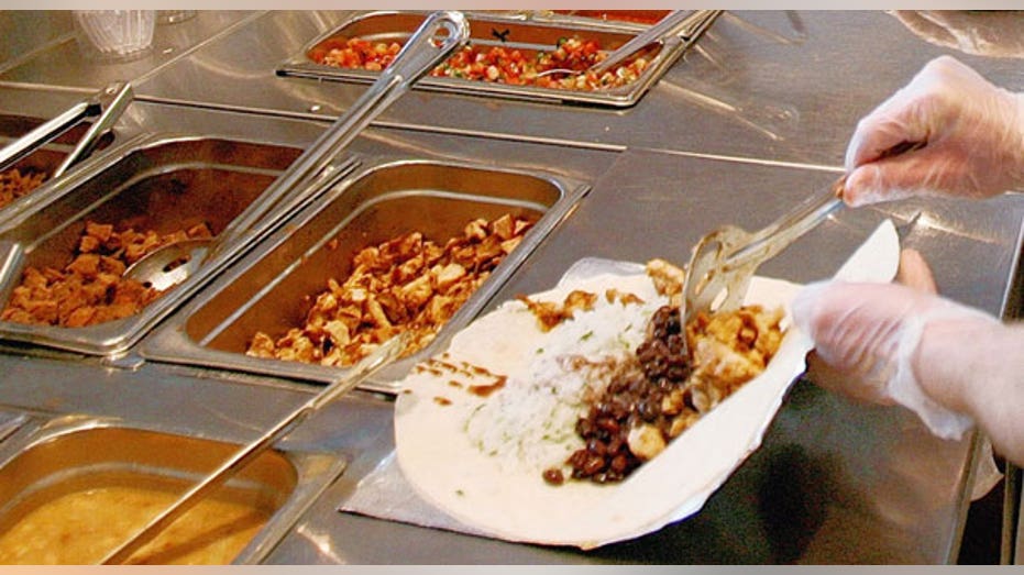 chipotle employee puts together burrito