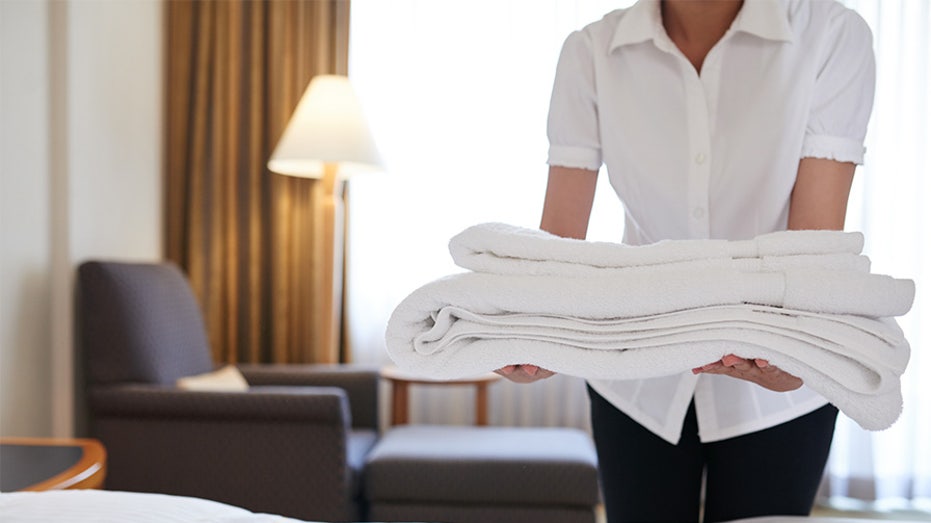 Hotel maid bringing fresh towels to the room