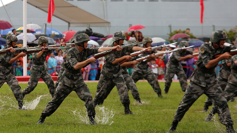 People's Liberation Army Navy soldiers perform at a naval base in Hong Kong, China July 8, 2017. REUTERS/Bobby Yip - RC1454D86220