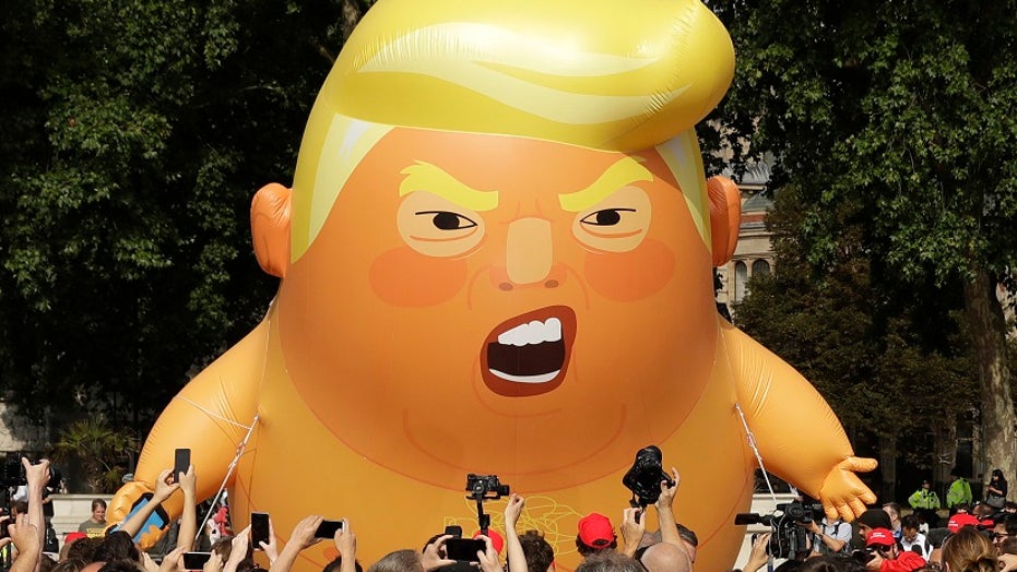 Image result for Trump fan arrested by police after stabbing and deflating  'Baby Trump' protest balloon  at football game     ,  photos