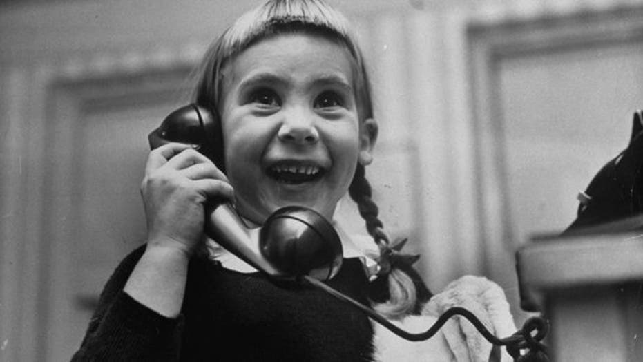 Photos of kids on the phone with Santa, 1947