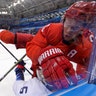 Russian Sergei Andronov (11) checks Noah Welch (5) during the second period of the preliminary round