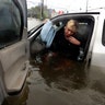Rhonda Worthington talks on her cell phone with a 911 dispatcher after her vehicle stalled in rising floodwaters in Houston, Monday