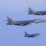 Two USAF B-1B Lancers accompany a Japan Air Self-Defense Force F-2 fighter jet into Japanese airspace and over the Korean Peninsula