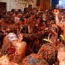 Revelers celebrate the Tomatina by throwing ripe tomatoes and drenching each other in pulp.