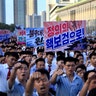 North Koreans rally at Kim Il Sung Square carrying placards in a show of support for leader Kim Jong-un in Pyongyang, August 9