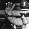 Gen. Manuel Antonio Noriega waves to newsmen after a state council meeting, at the presidential palace in Panama City.