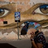 A woman walks past a mural by British street artist My Dog Sighs in Rome's Trastevere neighborhood, September 24, 2018