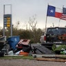 The Texas state flag and American flag wave over an area of debris left behind in the wake of Hurricane Harvey, Sunday, in Rockport, Texas