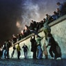 East German citizens climb the Berlin wall at the Brandenburg Gate after the opening of the East German border, November 10, 1989