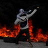 A Palestinian protester hurls stones towards Israeli troops during a protest against U.S. President Donald Trump in Ramallah, December 7
