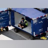 An American Airlines grounds crew member sits in a luggage cart at Sky Harbor International Airport to avoid the heat in Phoenix, Tuesday