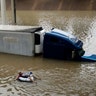 After helping the driver of the submerged truck get to safety, a man floats on the freeway flooded by Tropical Storm Harvey, in Houston, Sunday