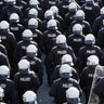 German riot police stand in front of protesters during demonstrations at the G-20 summit in Hamburg, Germany