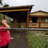 A woman reacts while looking at the damage to her house after the area was hit by Hurricane Maria in Guayama, Puerto Rico, Wednesday