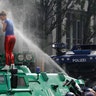 A woman is pepper-sprayed by police after she climbed on an armored police vehicle at the G-20 summit in Hamburg, Germany, Friday