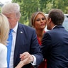 French President Emmanuel Macron kisses First Lady Melania Trump while his wife Brigitte welcomes President Donald Trump in Paris