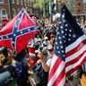 White nationalist demonstrators walk into Lee park surrounded by counter demonstrators in Charlottesville, Va., August 12