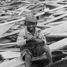 A boy sitting on debris in the wake of the 1900 hurricane, Galveston, Texas.