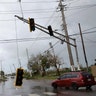 Cars drive past a damaged traffic light after the area was hit by Hurricane Maria in Guayama, Puerto Rico, Wednesday