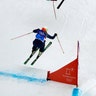 India Sherret of Canada, crashes as Emily Sarsfield of Britain, jumps during the women's ski cross elimination round at the Winter Olympics