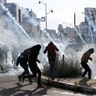 Palestinian protesters run from tear gas fired by Israeli troops during clashes in Ramallah, December 7